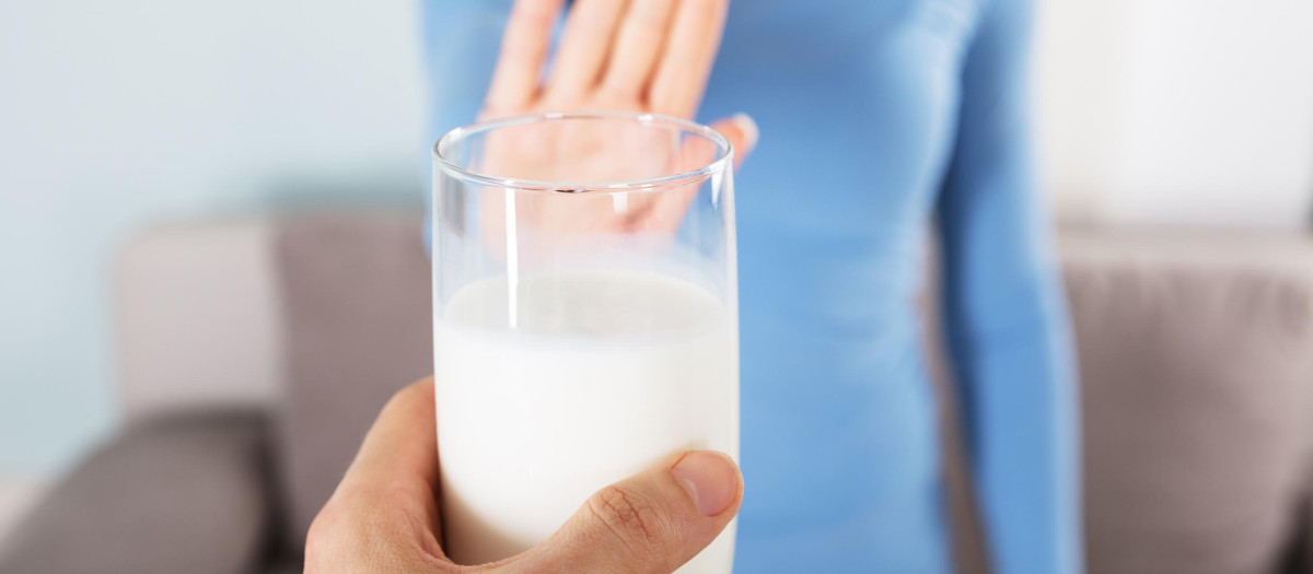 Close-up Of A Woman Rejecting Glass Of Milk At Home