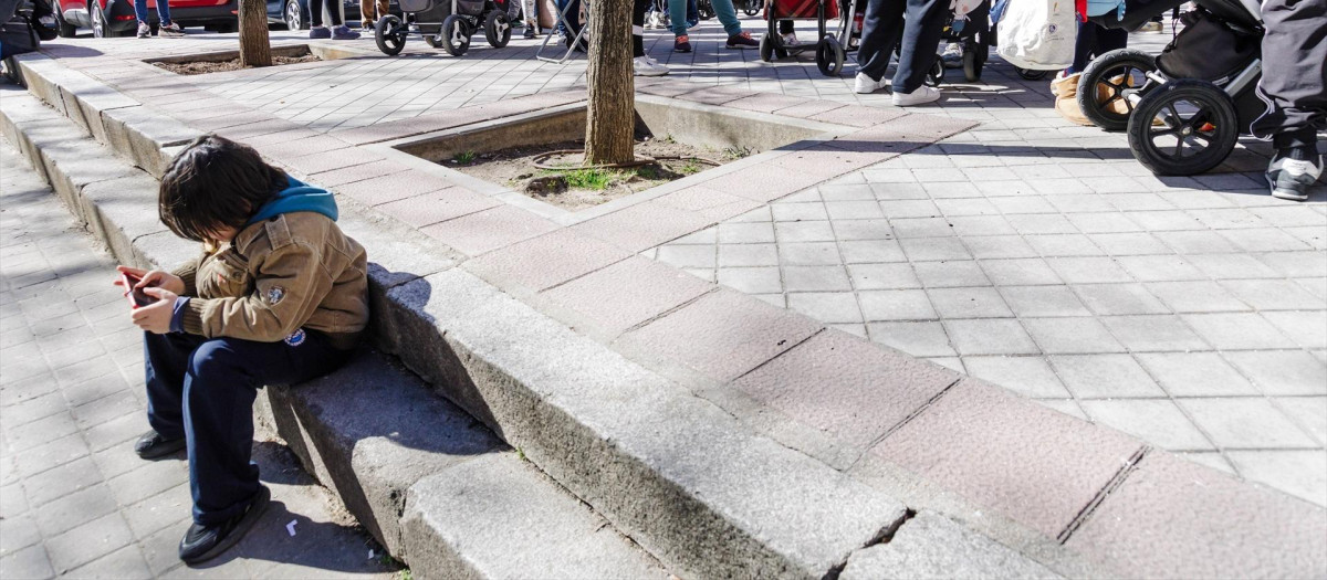 Un grupo de persona espera una cola durante la entrega de ropa de abrigo y zapatos nuevos a niños vulnerables