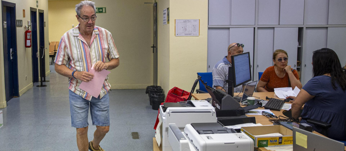 Un hombre presenta la documentación para tratar de eximirse de acudir a la mesa electoral