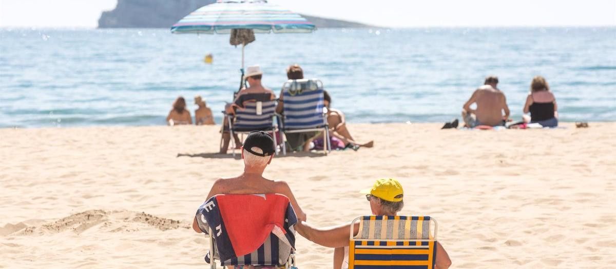 Numerosas personas se bañan y toman el sol en la playa de Poniente, Benidorm, Alicante