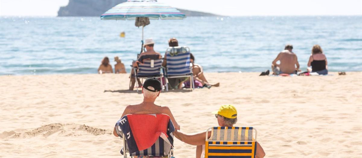 Numerosas personas se bañan y toman el sol en la playa de Poniente, Benidorm, Alicante