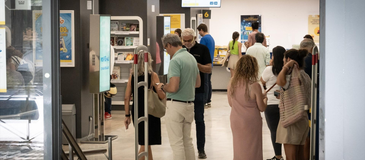Varias personas votan por correo en Madrid.