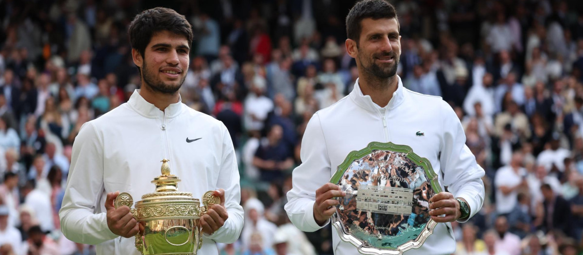 Carlos Alcaraz y Novak Djokovic posan ante los medios de comunicación con los trofeos correspondientes