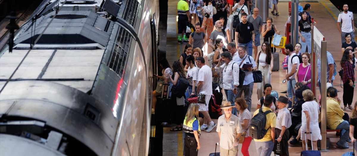 Varias personas con maletas en el andén de Renfe de la estación de Atocha.