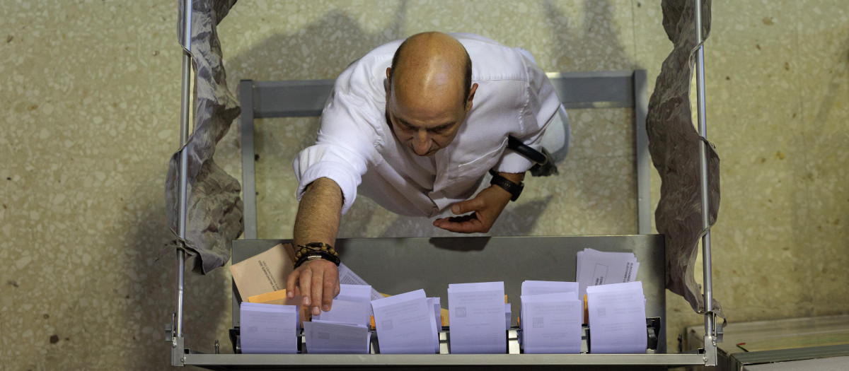 Un hombre escogiendo su papeleta para votar