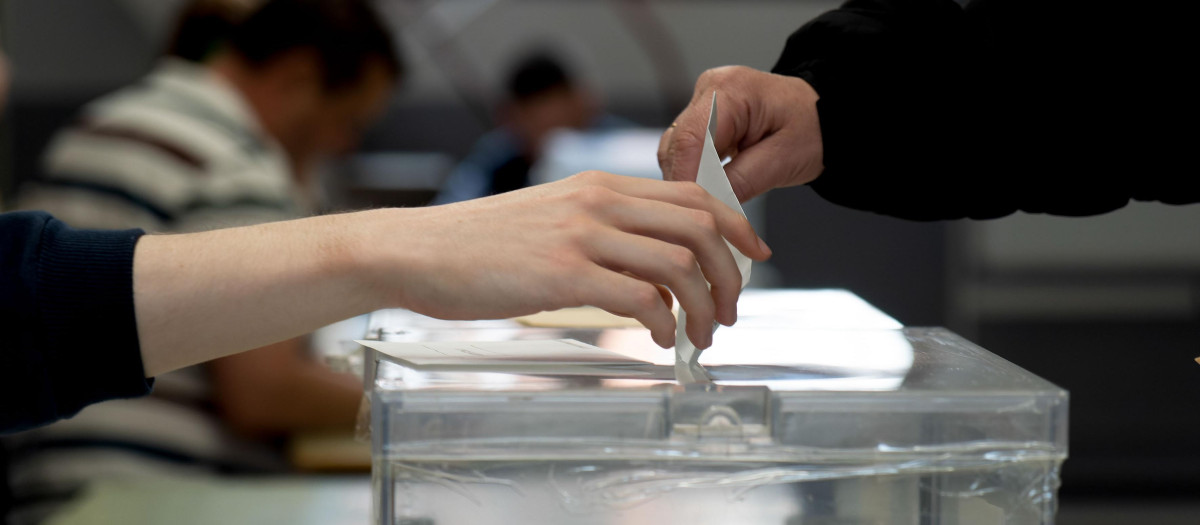 Un votante deposita su papeleta en la urna en un colegio electoral de Teruel