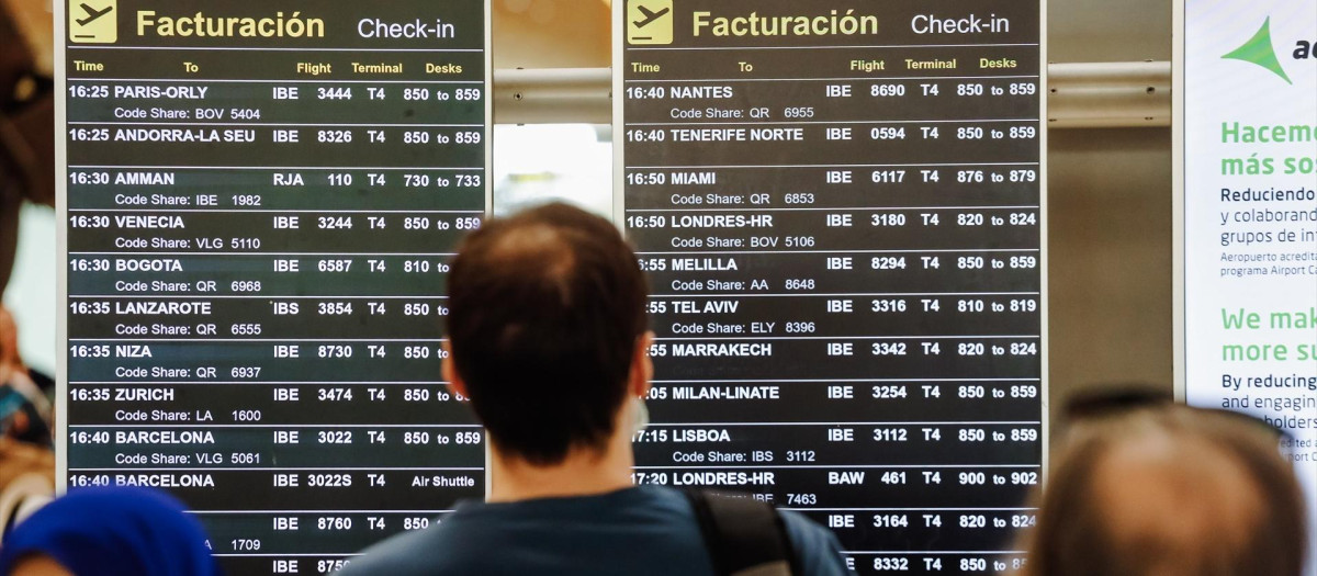 Pasajeros observan las pantallas de Barajas.