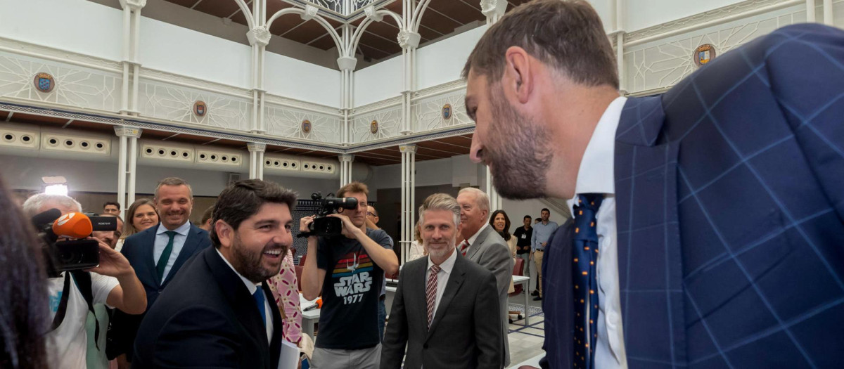 El presidente en funciones de la Comunidad de Murcia Fernando López Miras (i), saluda al portavoz de Vox, José Ángel Antelo