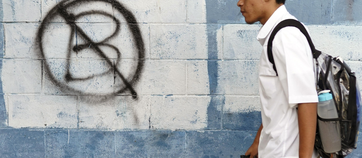 Un estudiante pasea ante una pintada contra el bitcóin