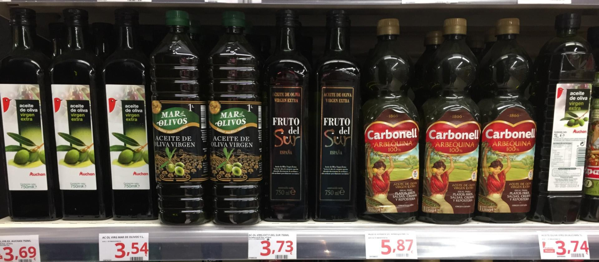 Botellas de aceite de oliva en la estantería de un supermercado