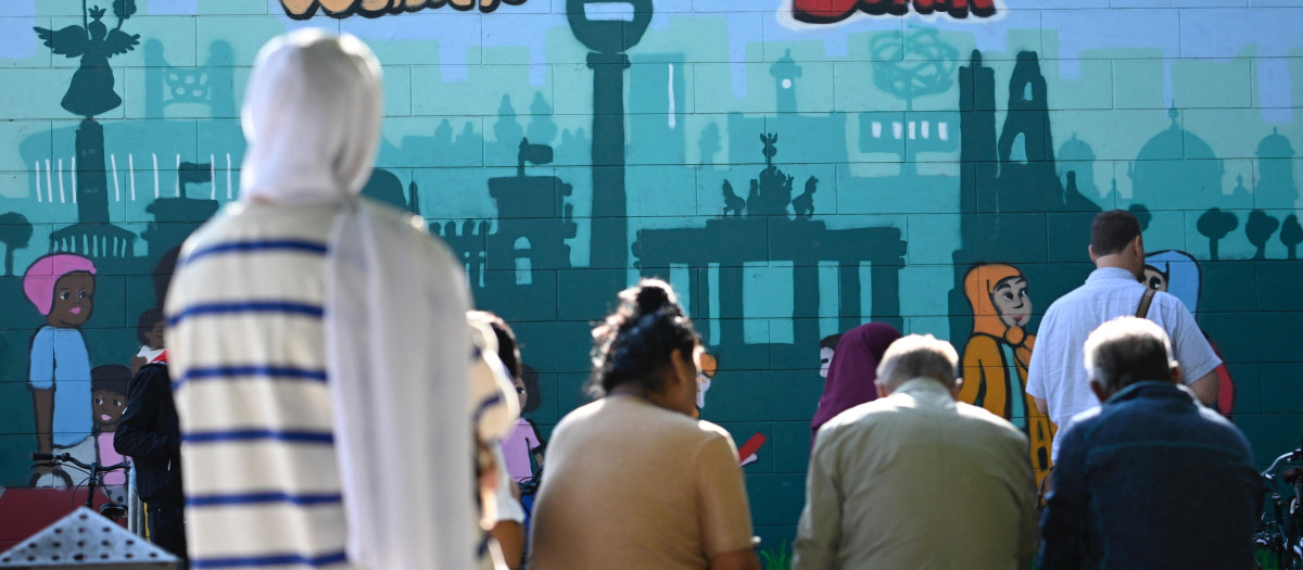 Un grupo de personas se reúne frente a la entrada de una oficina de inmigración en Berlín, Alemania