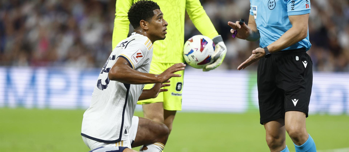 El centrocampista inglés del Real Madrid Jude Bellingham (i) ante el árbitro Soto Grado (d)