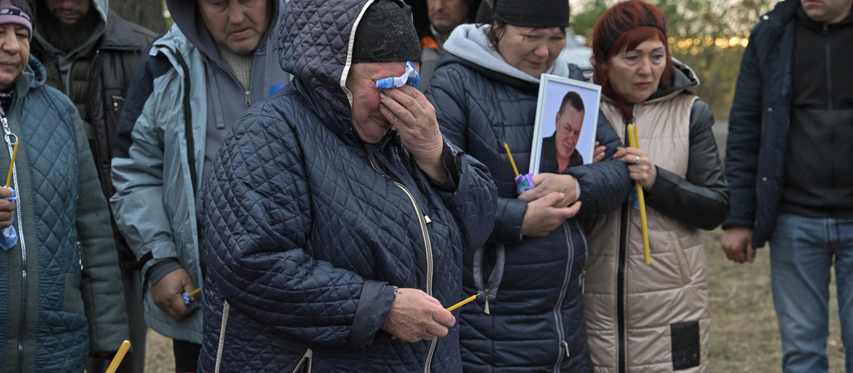 Familiares y amigos lloran ante un ataúd en la aldea de Groza, Ucrania