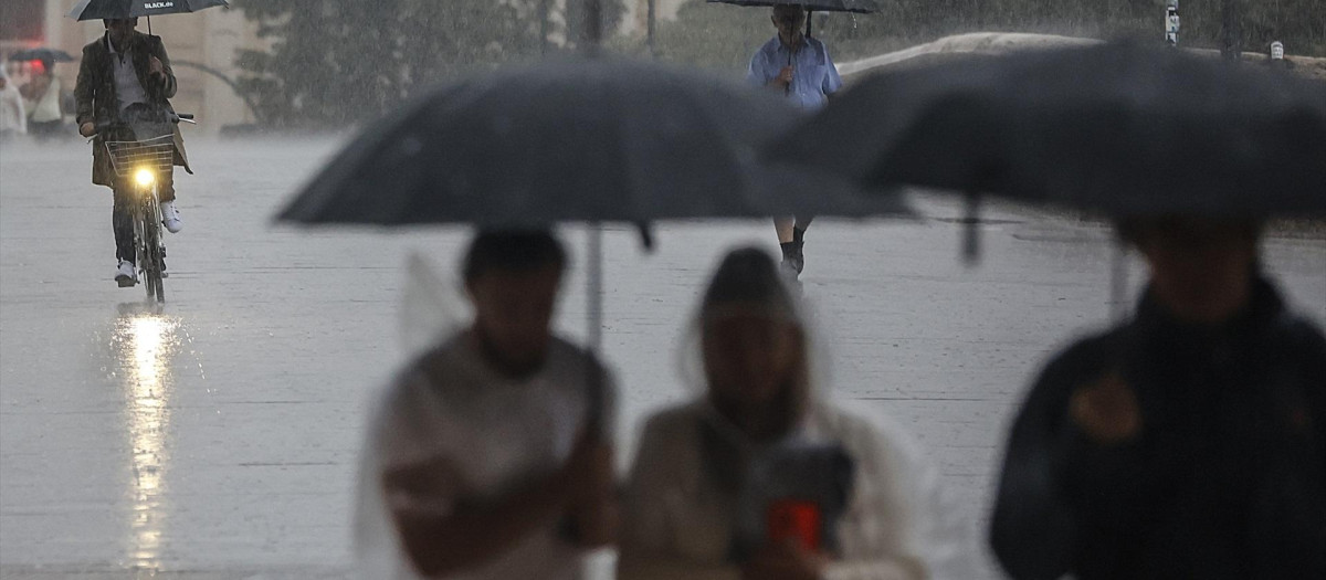 Varias personas con paraguas bajo la lluvia en Valencia