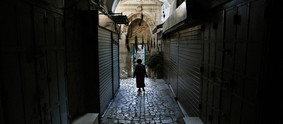 Una mujer camina por el barrio cristiano de Jerusalén, 16 de octubre de 2023