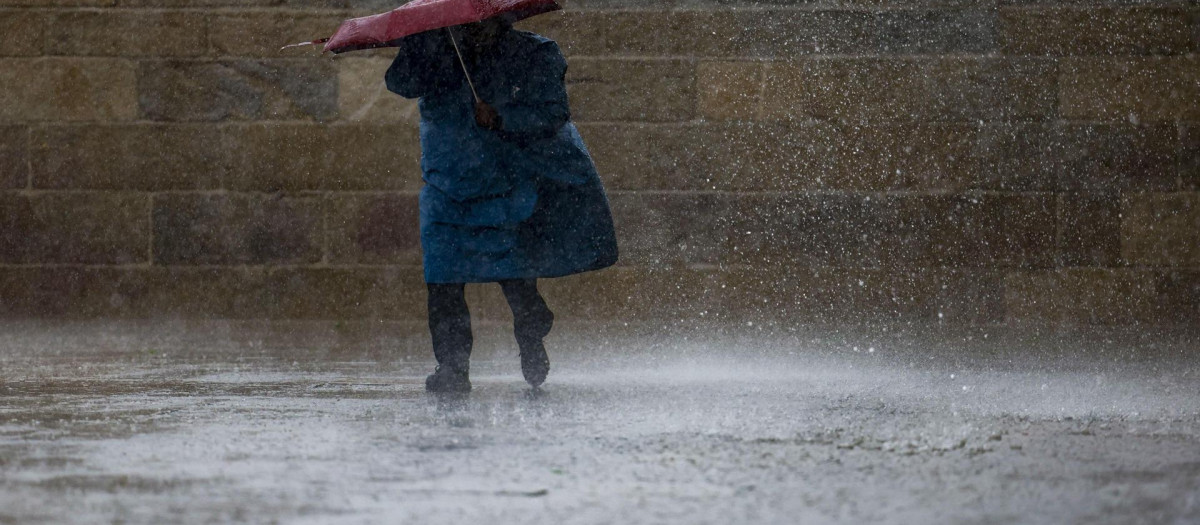 Un peregrino bajo la lluvia este sábado en la plaza del Obradoiro en Santiago de Compostela