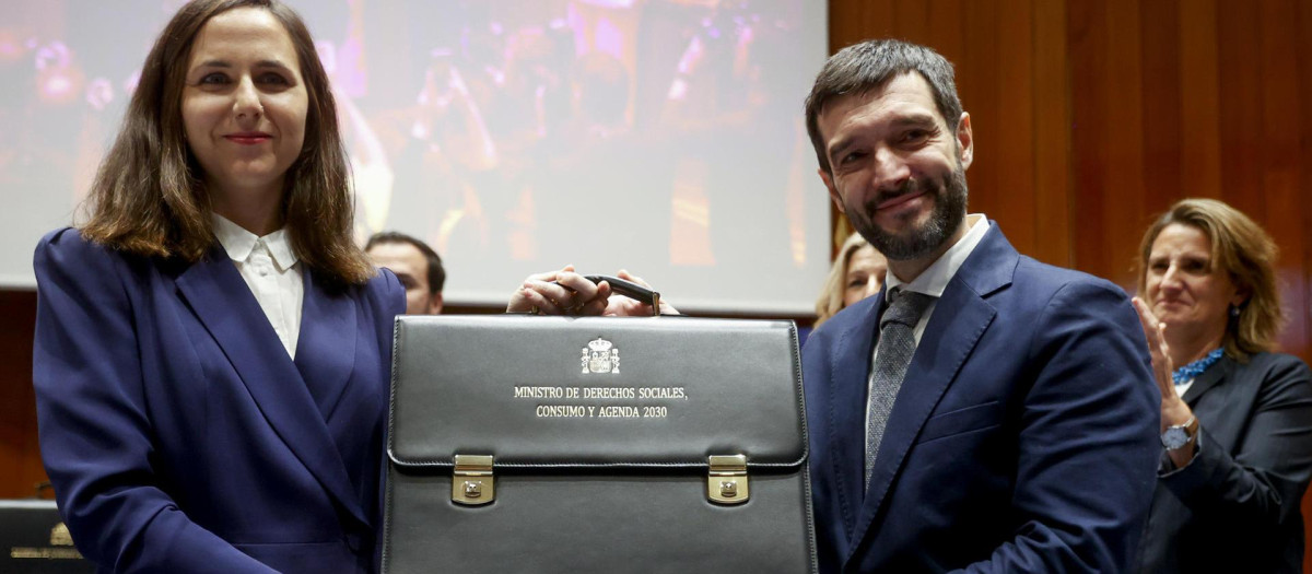El nuevo ministro de Derechos Sociales, Consumo y Agenda 2030, Pablo Bustinduy (d), recibe el maletín de la exministra de Derechos Sociales Ione Belarra