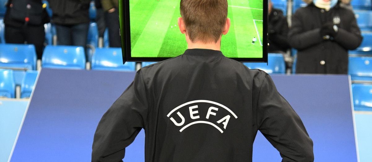 Un árbitro revisando una acción en el VAR en un partido de Champions League
