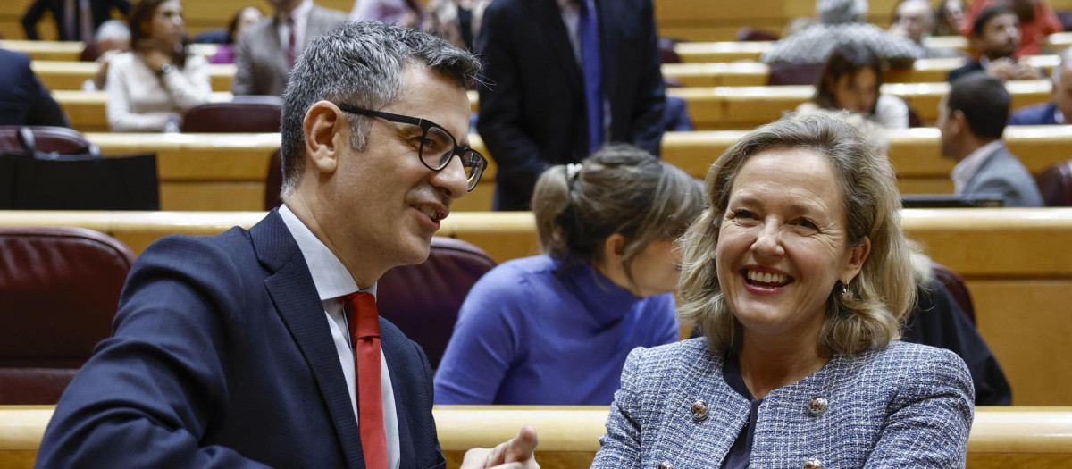 MADRID, 12/12/2023.- El ministro de Presidencia, Félix Bolaños conversa con la vicepresidenta primera del Gobierno español y responsable de Economía, Nadia Calviño, durante la sesión de Control al Gobierno celebrada este martes por el pleno del Senado. EFE/ Sergio Pérez
