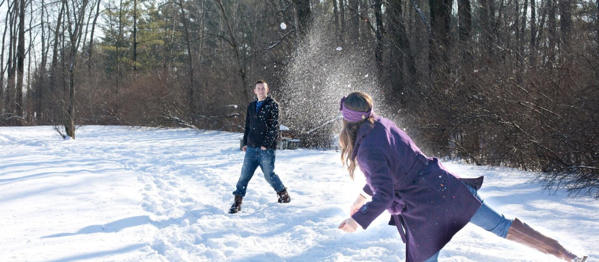 Una pareja jugando en la nieve durante sus vacaciones de invierno