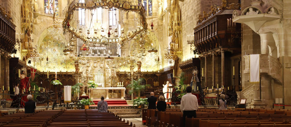 11 May 2020, Spain, Palma: Believers pray in the cathedral of Palma de Mallorca.