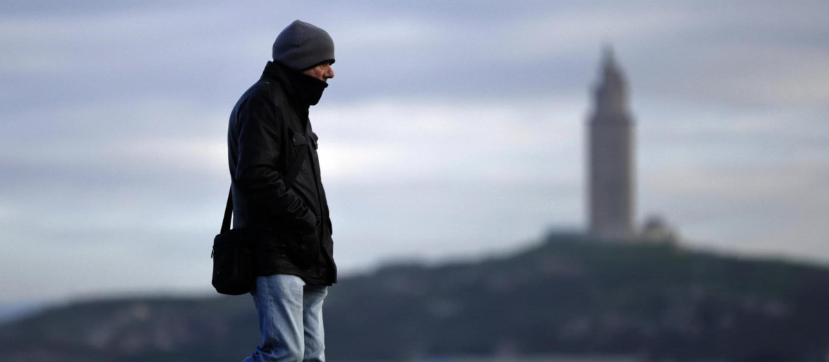 Un hombre camina por el paseo marítimo de La Coruña