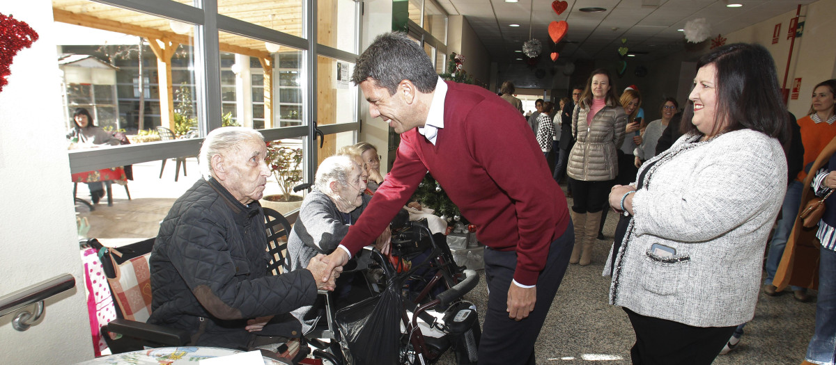 Carlos Mazón saluda a un anciano en una residencia de mayores en Petrer, Valencia, esta Nochebuena