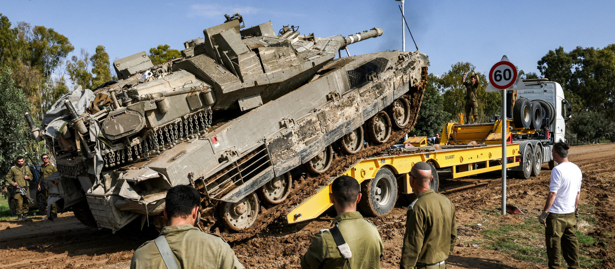 Un tanque de combate israelí es replegado de la frontera con Gaza