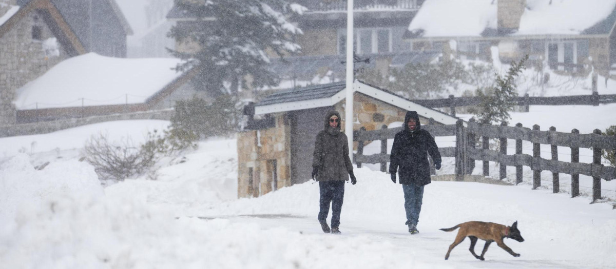 Varias personas caminan sobre la nieve este domingo en la localidad cántabra de Brañavieja