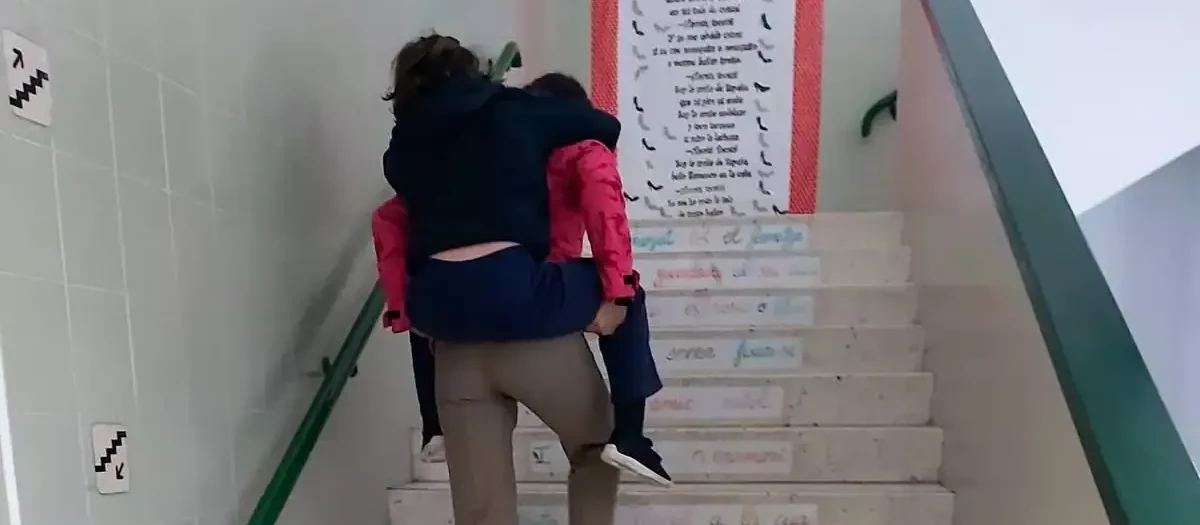 Madre subiendo a sus hijos por las escaleras