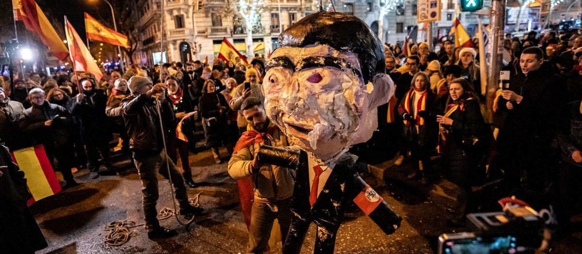 Decenas de personas celebran la entrada del año nuevo en la calle Ferraz, a 1 de enero de 2024, en Madrid (España). Revuelta, la organización juvenil de la órbita de Vox convocante de las concentraciones en Ferraz, ha llamado a tomar las uvas esta Nochevieja frente a la sede federal del PSOE, siguiendo la estela de las manifestaciones contra la amnistía que se suceden allí desde hace semanas.
31 DICIEMBRE 2023;UVAS;REVUELTA;MANIFESTACIÓN;FERRAZ;AMNISTÍA;PSOE;
Diego Radamés / Europa Press
01/1/2024