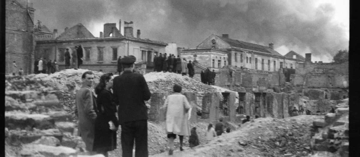 Los edificios del hospital del Espíritu Santo en la calle Elektoralna 12, destruidos en 1939; al fondo, humo del gueto en llamas, abril-mayo de 1943