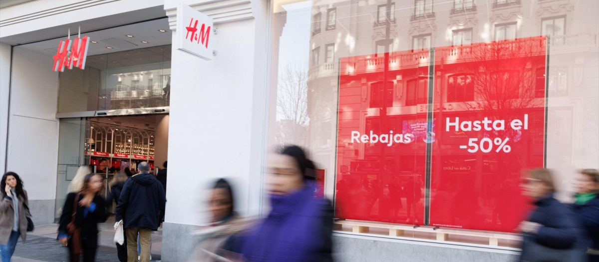 Varias personas caminan frente a una tienda de H&M.