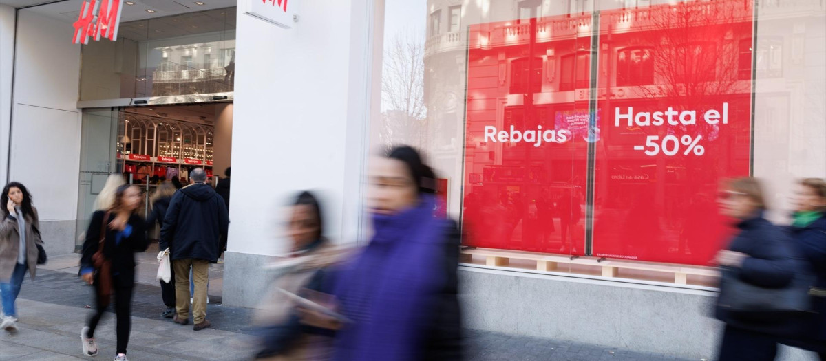 Varias personas caminan frente a una tienda de H&M.