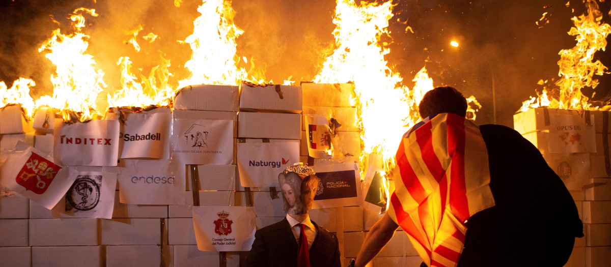 Mienbros de los Comités de Defensa de la República (CDR) queman un retrato del rey Felipe VI, hoy viernes tras la manifestación convocada por la CUP en el centro de Barcelona con motivo de la Diada del 11 de septiembre de 2020