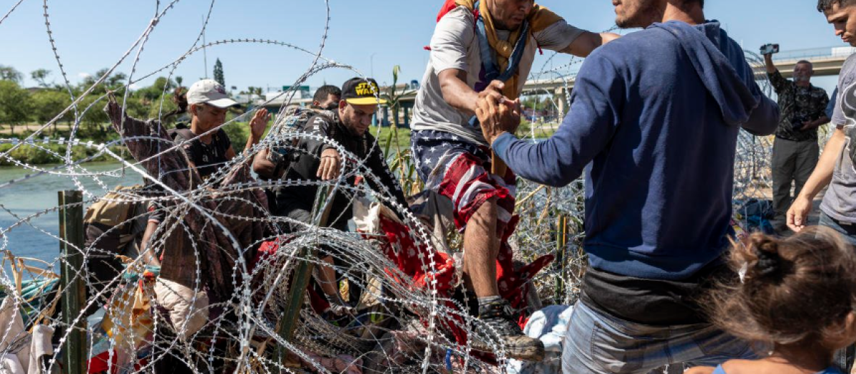 Varias personas cruzan la valla en Texas