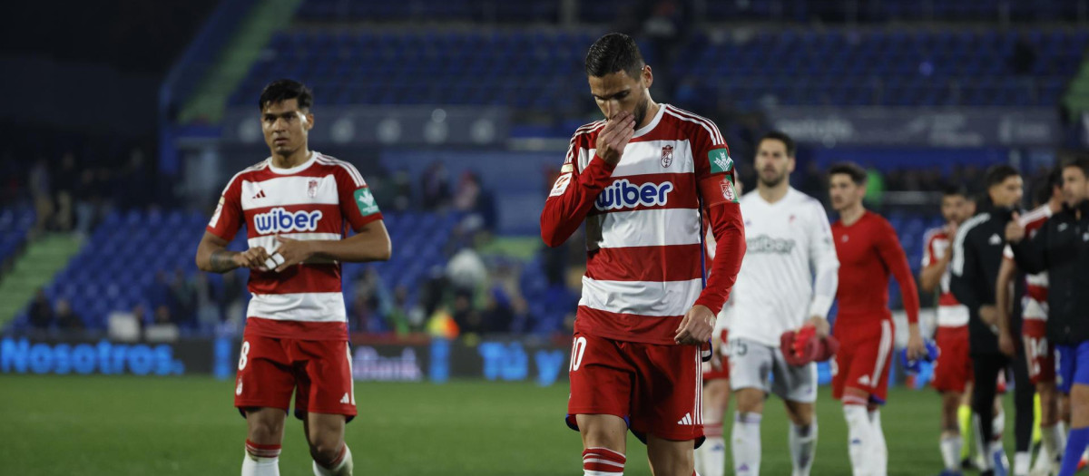 Los jugadores del Granada abandonan cabizbajos el campo tras la derrota ante el Getafe