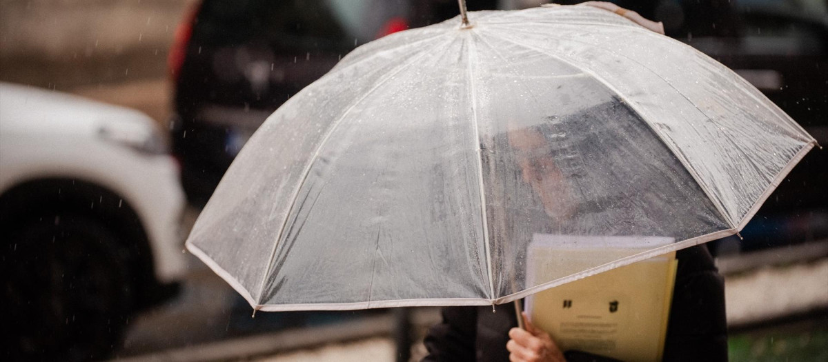 Una persona se protege de la lluvia con paraguas