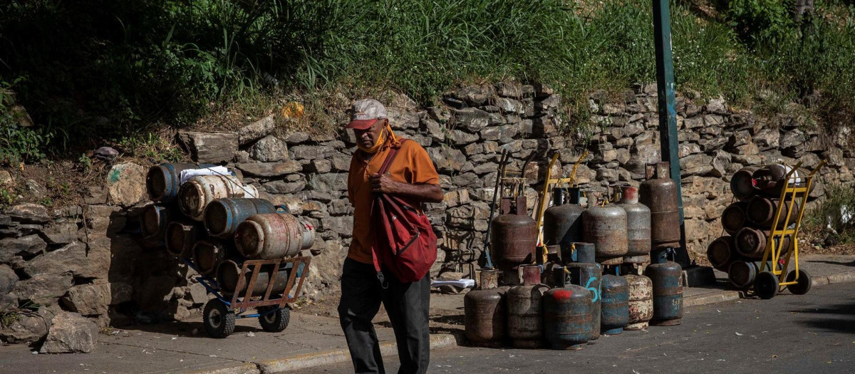 Un hombre camina frente a bombonas vacías de gas, el 27 de octubre de 2020, en Caracas (Venezuela)