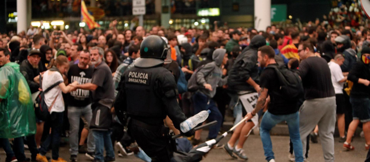 Un mosso d'esquadra durante una de las cargas contra las miles de personas se agolpan ante el Aeropuerto del Prat después de que la plataforma Tsunami Democràtic haya llamado a paralizar la actividad del aeropuerto, en protesta por la condena a los líderes del 'procés