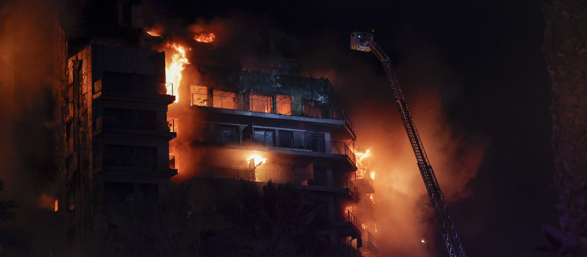 Vista del incendio declarado sobre las cinco y media de esta tarde en un quinto piso de un edificio de viviendas de València que ha afectado totalmente al inmueble y se ha propagado a otro anexo, y los bomberos intentan aún rescatar a vecinos desde los balcones.