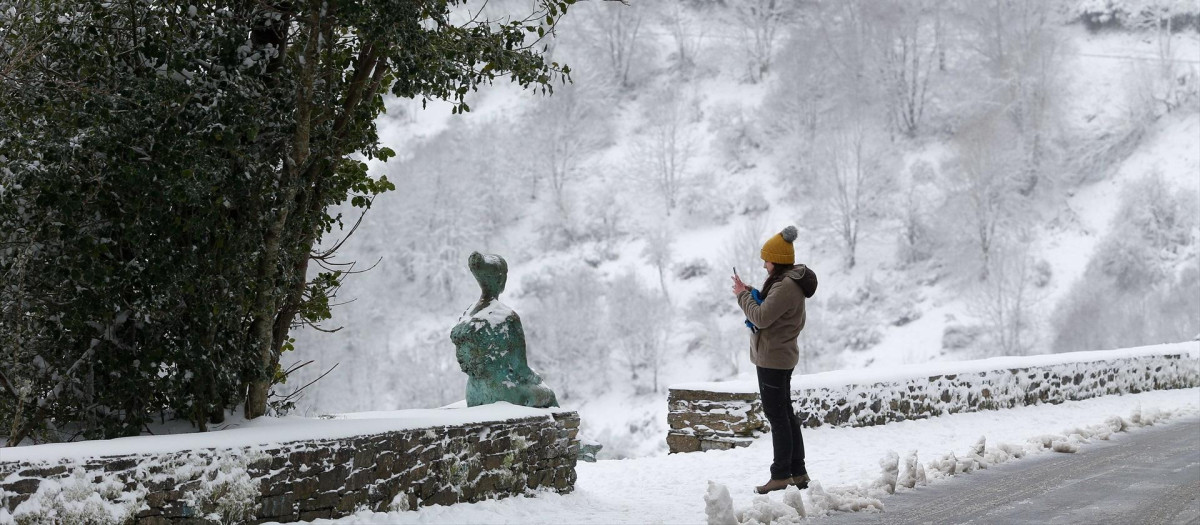 Una mujer camina sobre la nieve en Pedrafita do Cebreiro, Lugo, Galicia