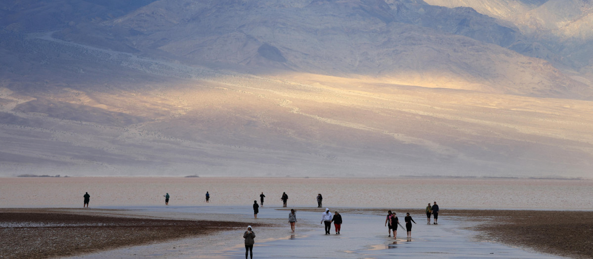 Los turistas disfrutan de la rara oportunidad de caminar en el agua mientras visitan Badwater Basin, el lugar normalmente más seco de EE.UU