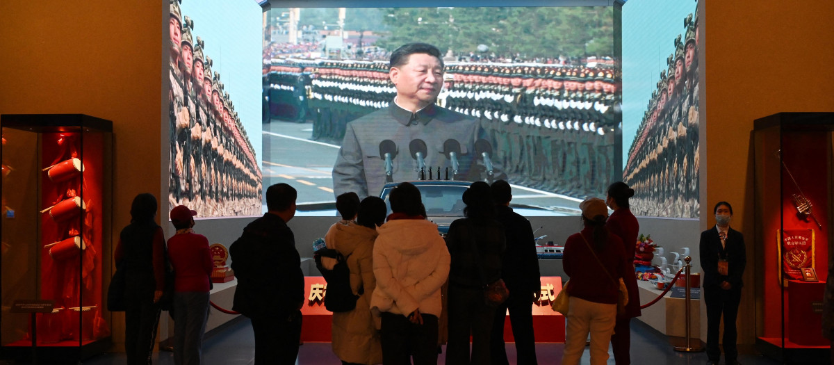 La gente mira un vídeo del presidente chino Xi Jinping en un desfile militar en el Museo del Partido Comunista de China en Pekín