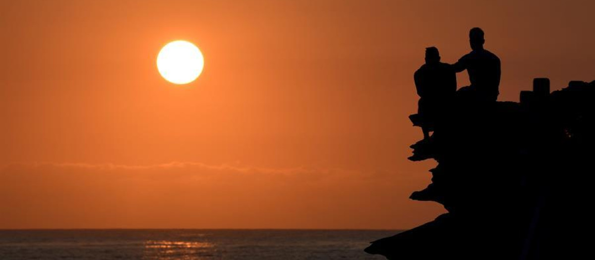 Dos hombres observan el amanecer en Sídney, Australia