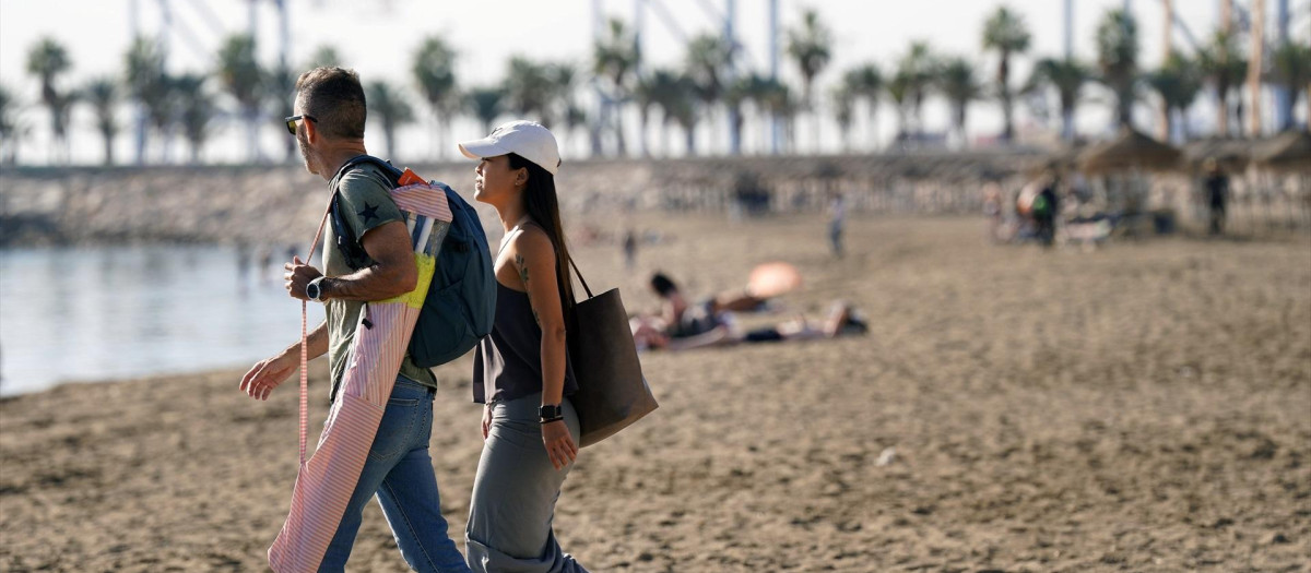 Varias personas disfrutan tomando el sol en la playa de la Malagueta en pleno invierno