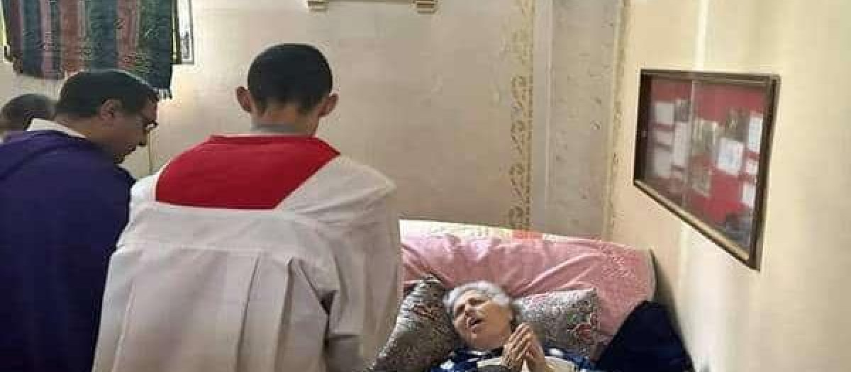 Sacerdote dando la Sagrada Comunión a una impedida