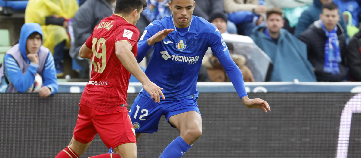 El delantero británico del Getafe Mason Greenwood (d) disputa un balón ante el defensa argentino Marcos Acuña del Sevilla, durante el partido entre el Getafe y el Sevilla FC, correspondiente a la jornada 30 de LaLiga, disputado este sábado en el Estadio Coliseum. EFE/ Zipi