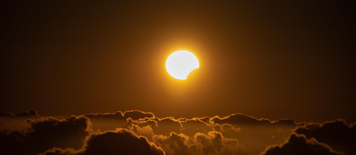 Las islas más occidentales de Canarias han sido uno de los pocos puntos de España desde donde se ha visto el eclipse solar de este 8 de abril, aunque de forma parcial. En la imagen, el eclipse sobre el mar de nubes, fotografiado desde Garafía, en las cumbres de La Palma.