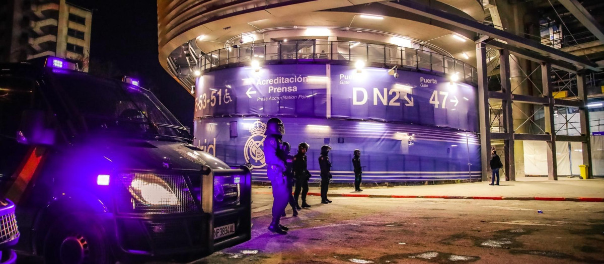 Agentes de policía escoltan a los aficionados en las inmediaciones del estadio Santiago Bernabéu